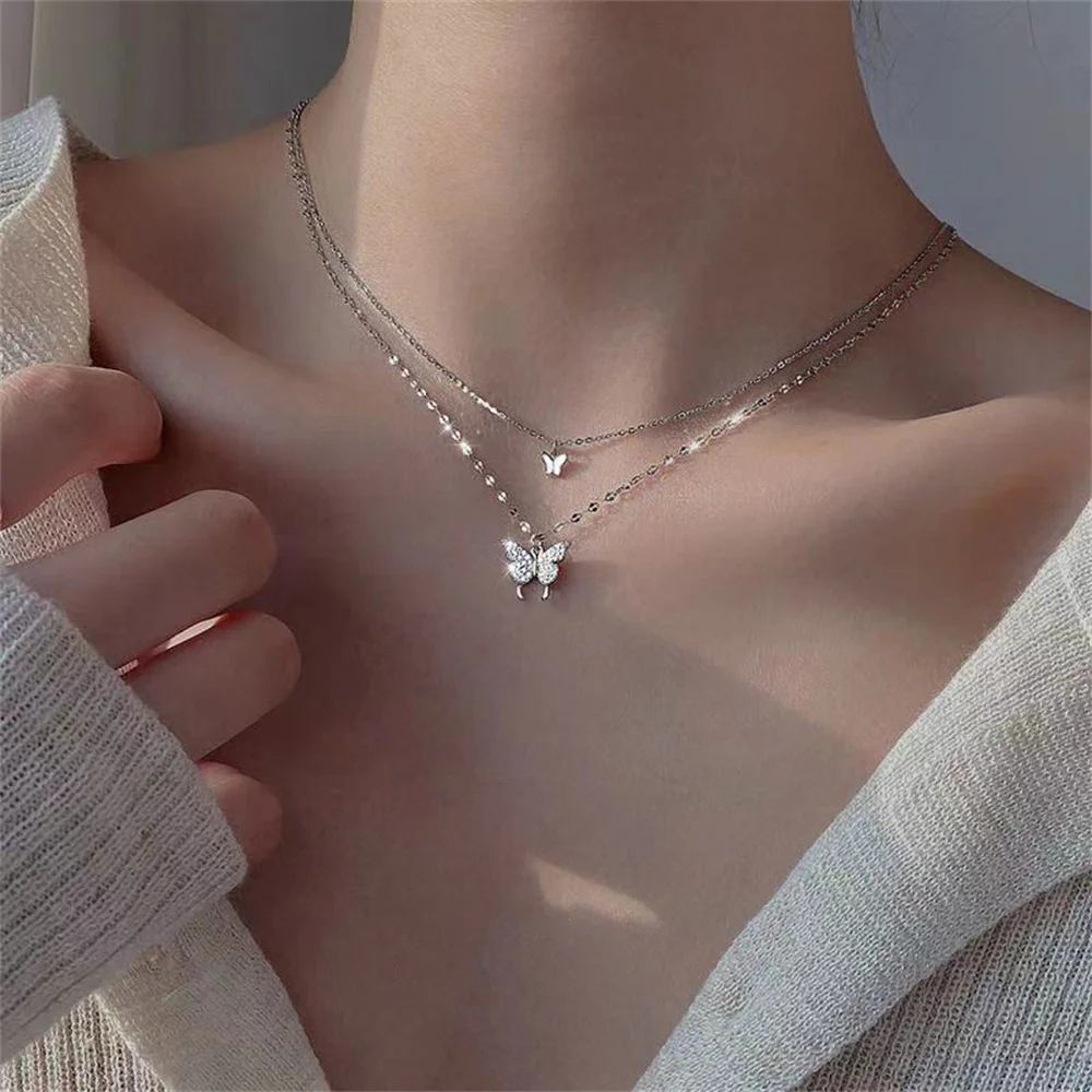 Layered butterfly necklaces on woman's neck.