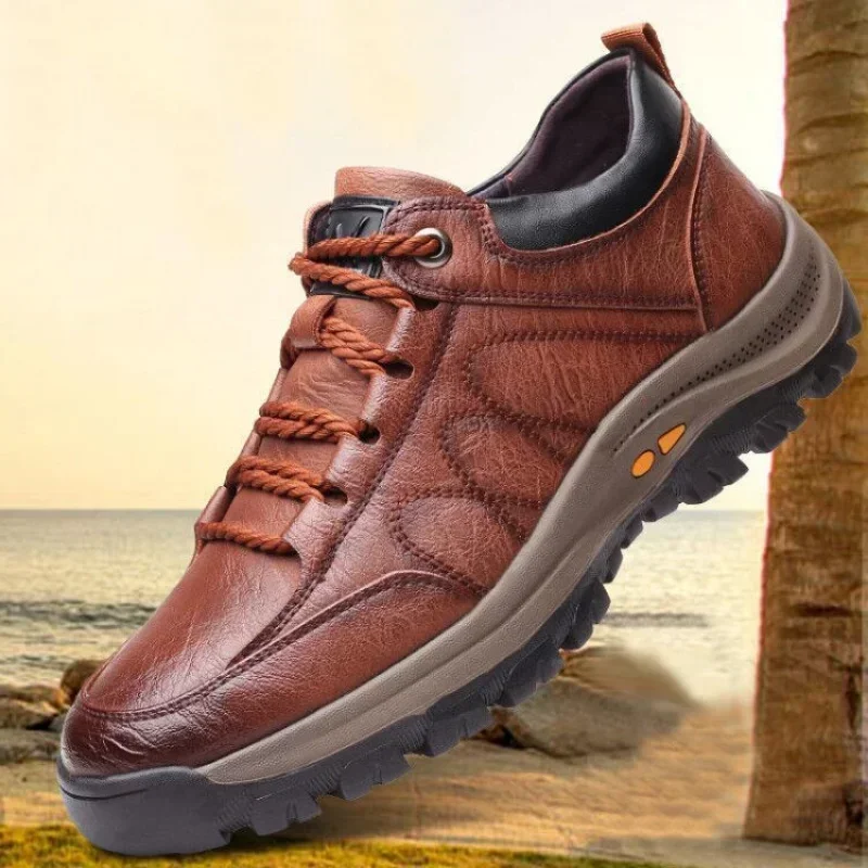 Brown leather hiking shoe with sturdy sole on sandy beach.