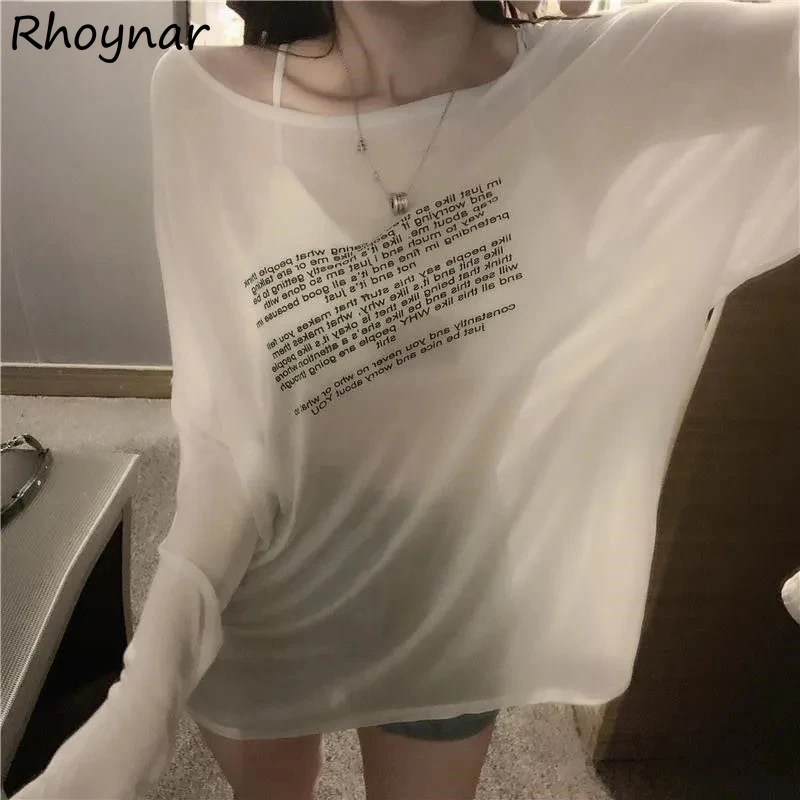 Person wearing a white oversized long-sleeve shirt with text on the front.