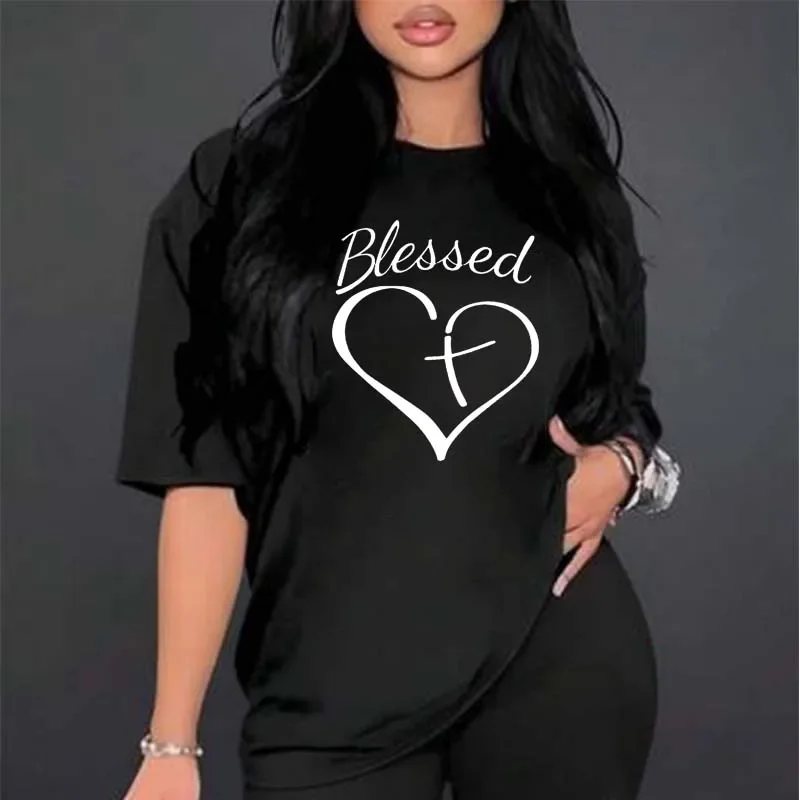 Woman wearing a black t-shirt with a heart and cross design.