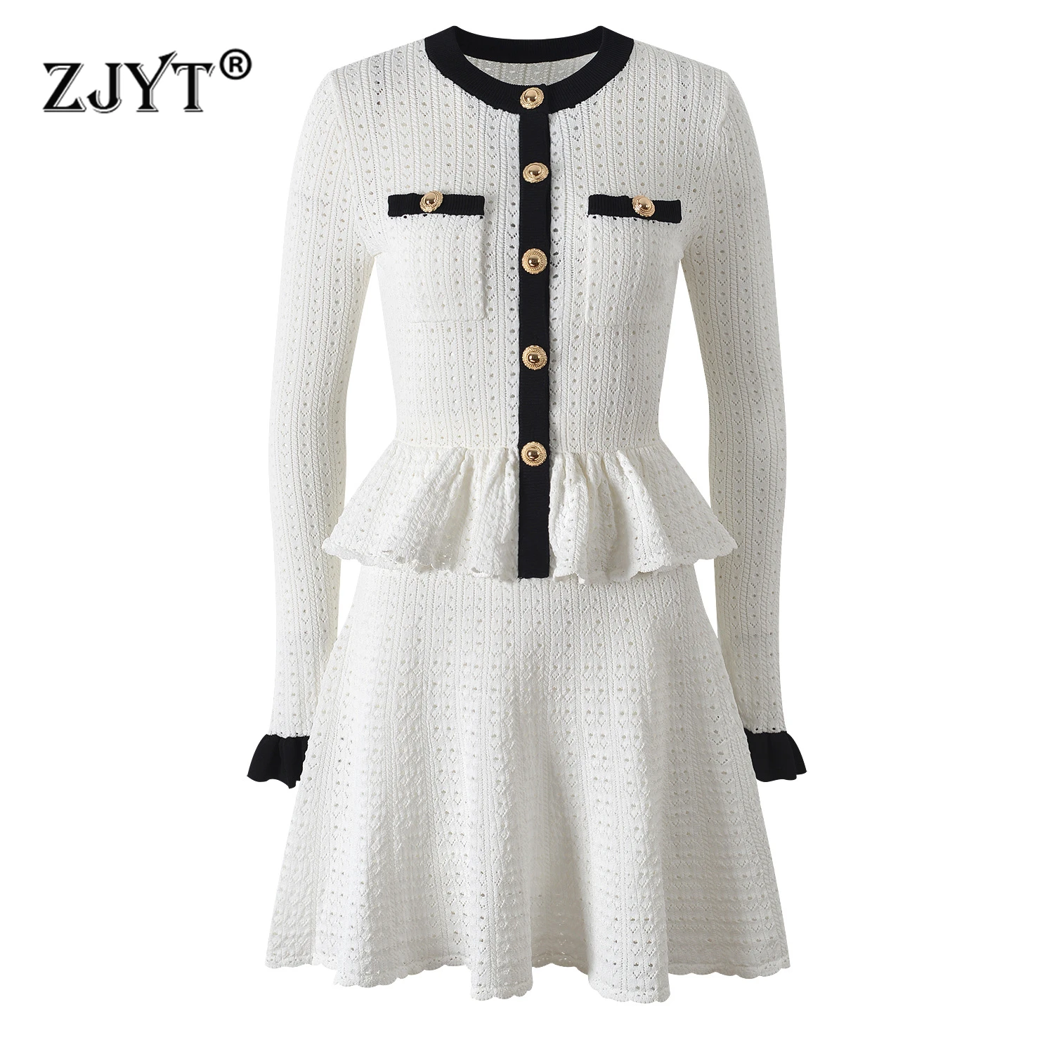 Elegant white knit dress with black trim and gold buttons.