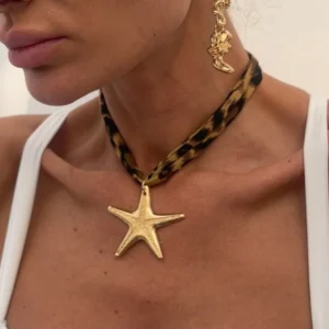 Woman wearing starfish necklace and moon earring.