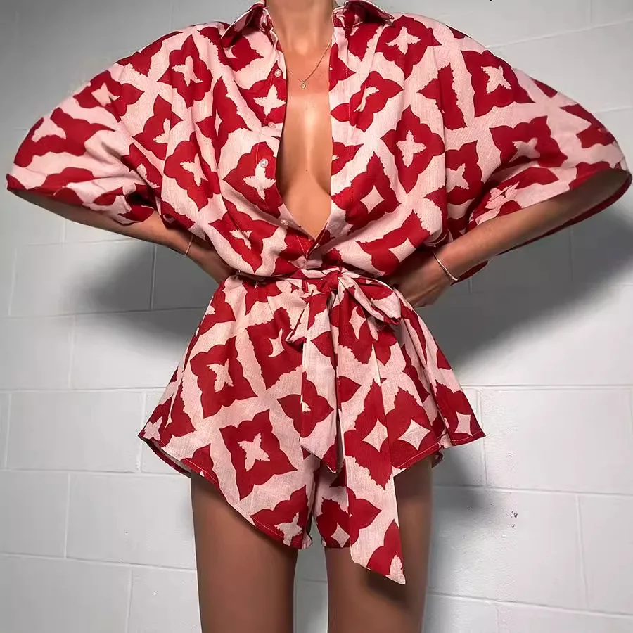 Model wearing a bold red and white patterned coat tied at the waist.