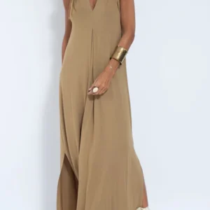 Woman wearing a tan sleeveless maxi dress with side slits.