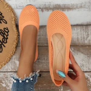 Pair of orange slip-on shoes with textured design.