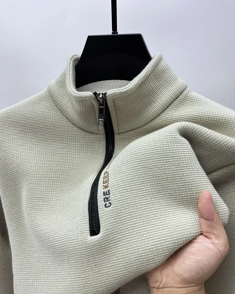 Beige textured zip-up sweater on hanger.