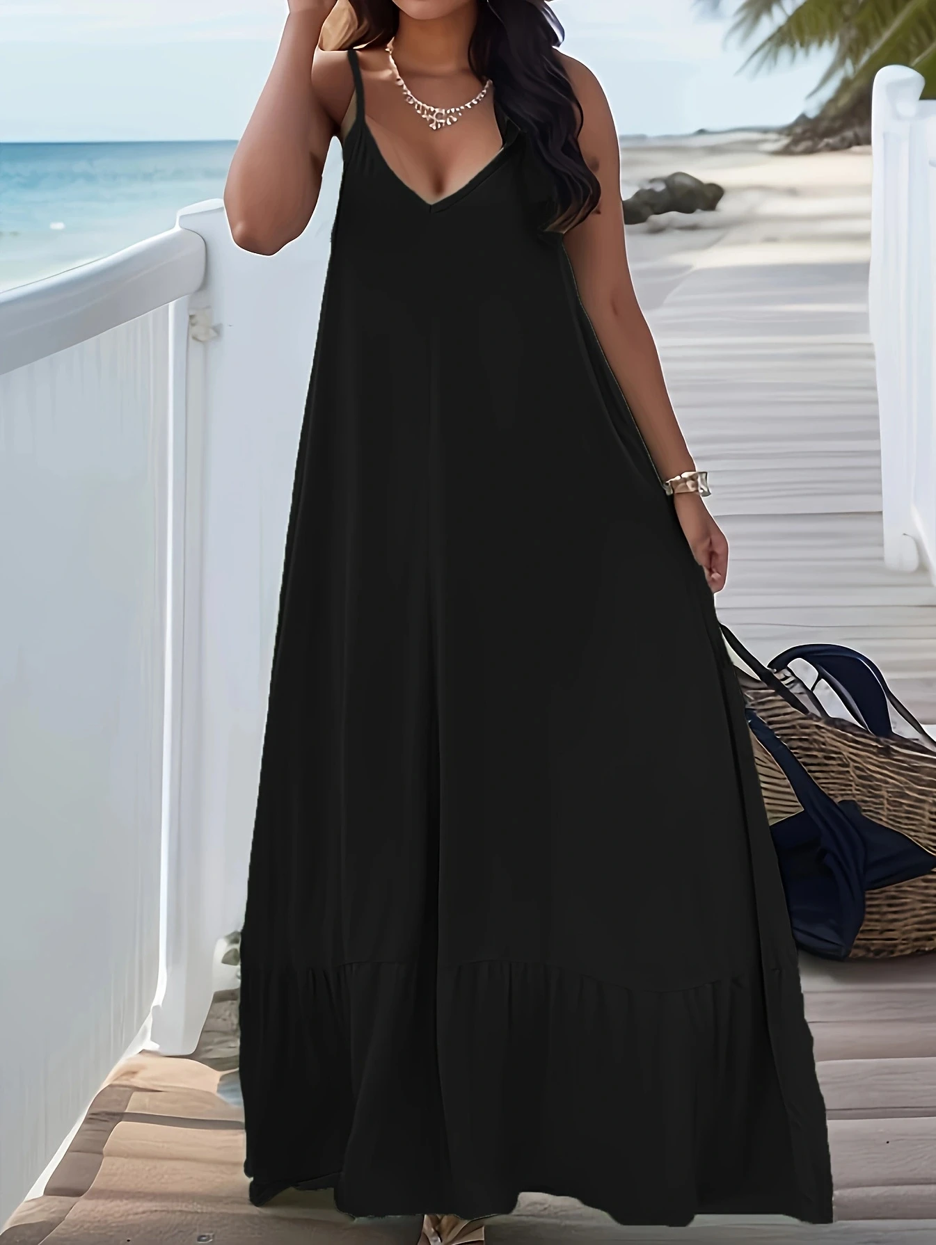 Woman wearing a long black dress standing by a white railing.