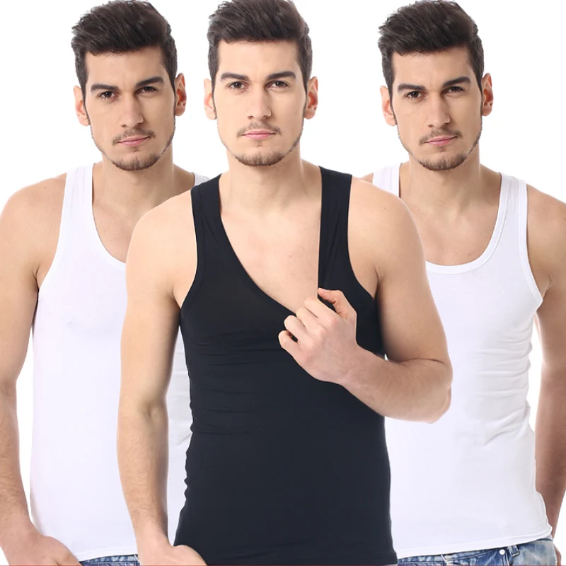 Three men in tank tops, posing together.