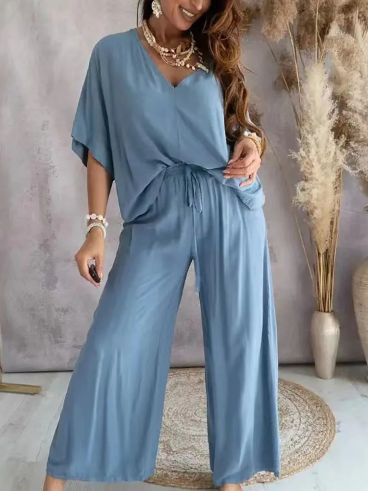 Woman wearing a comfortable blue wide-leg jumpsuit.