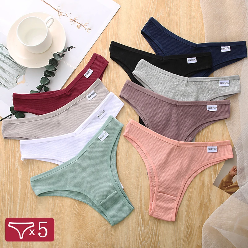 Five colorful women's thong panties neatly arranged on a wooden surface.