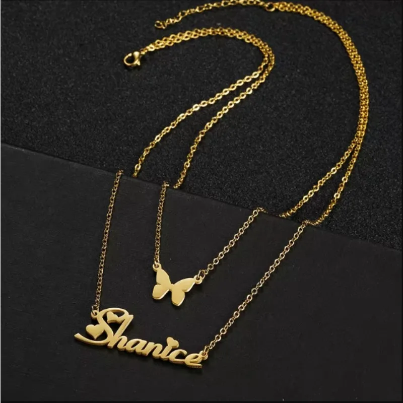 Gold necklaces with a butterfly pendant and a nameplate.
