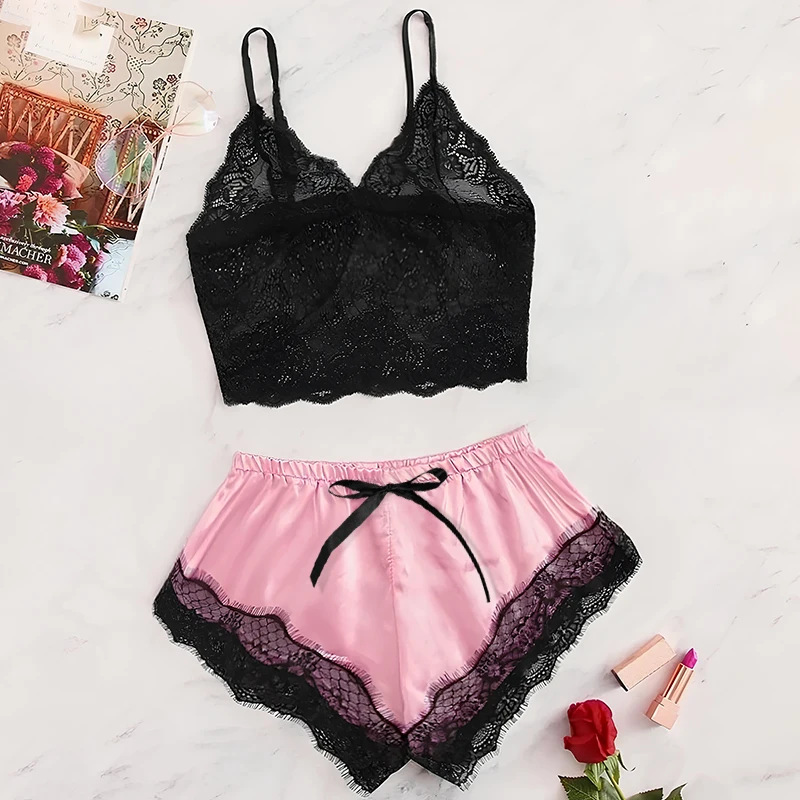 Black lace bralette with pink satin shorts featuring black lace trim and a bow.