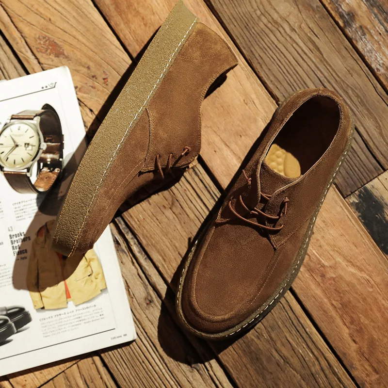 Pair of brown leather casual shoes on wooden surface.