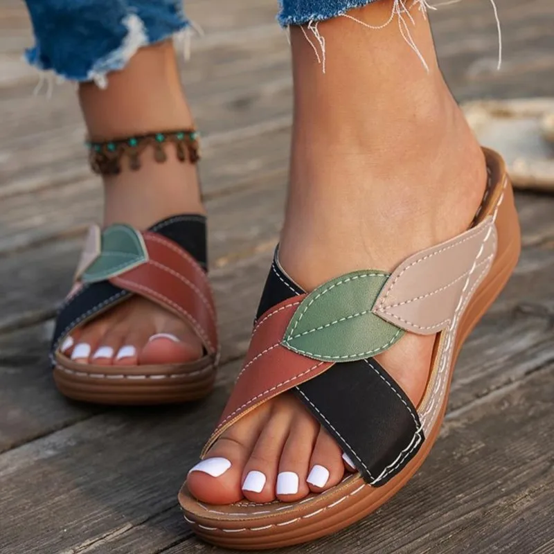 Close-up of feet wearing multicolored casual sandals on wooden floor.