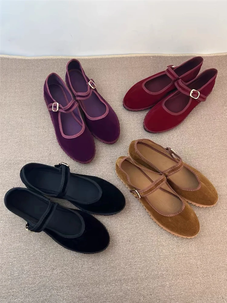 Four pairs of Mary Jane shoes in different colors arranged on a beige surface.