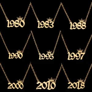 Gold year necklaces with crowns, black background.
