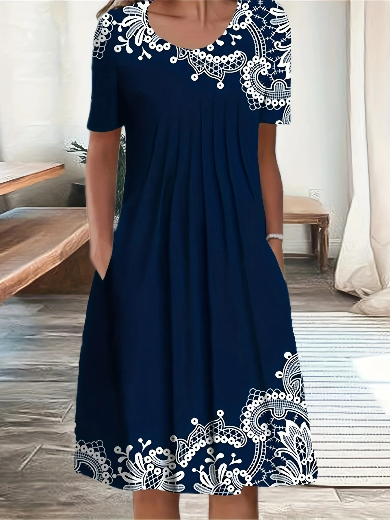 Navy blue dress with white floral lace detailing at hem and neckline, featuring short sleeves and pockets.
