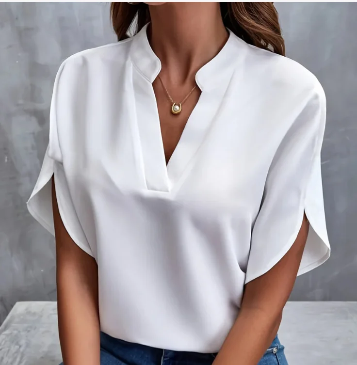 Woman wearing a stylish white blouse with a V-neck and short sleeves.