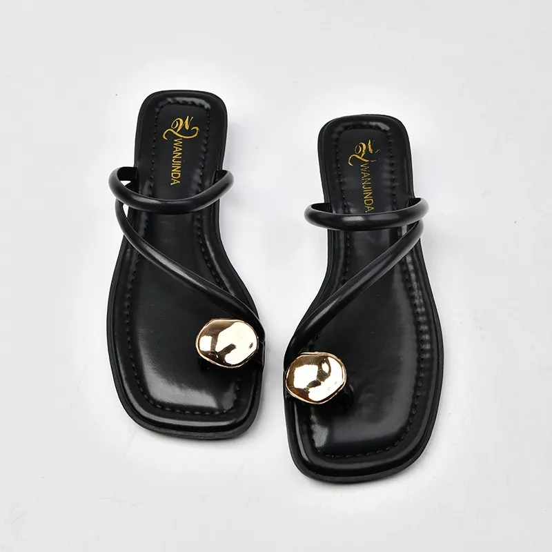 Pair of black square-toe sandals with gold accents.