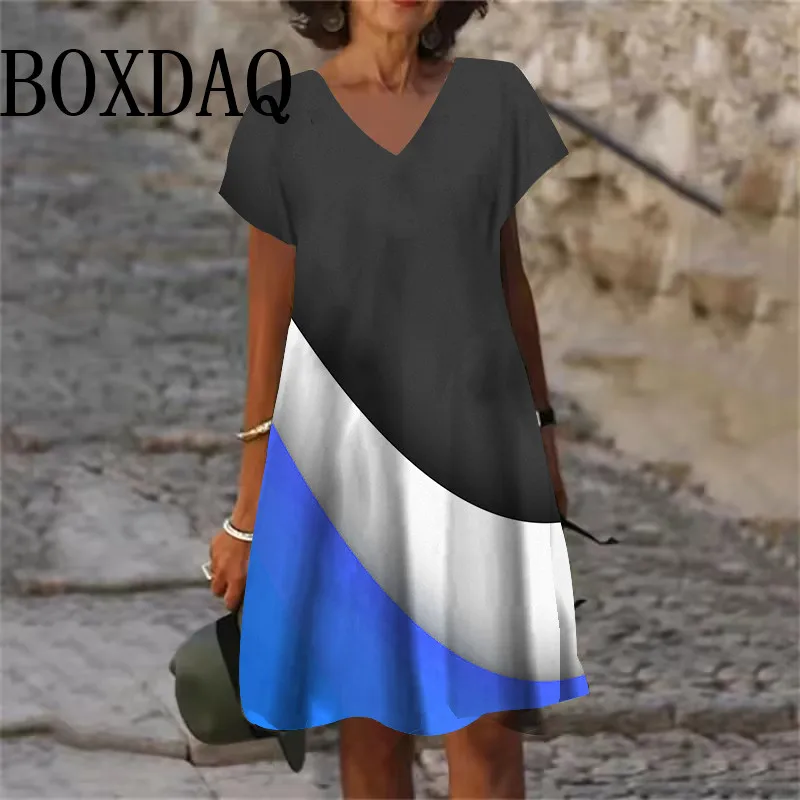 Woman wearing a stylish color-block dress with black, white, and blue sections.