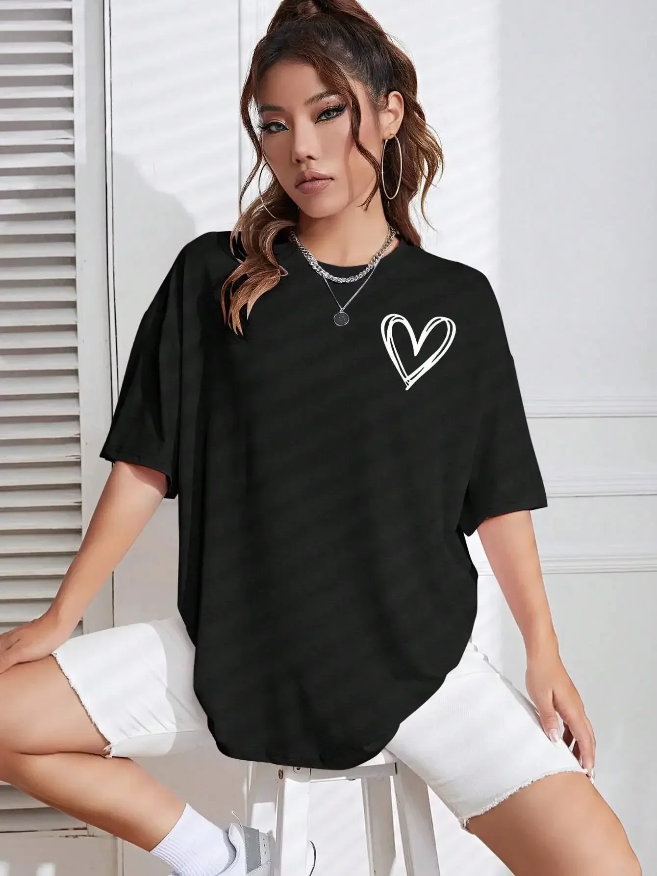 Black oversized t-shirt with a white heart design on the chest.