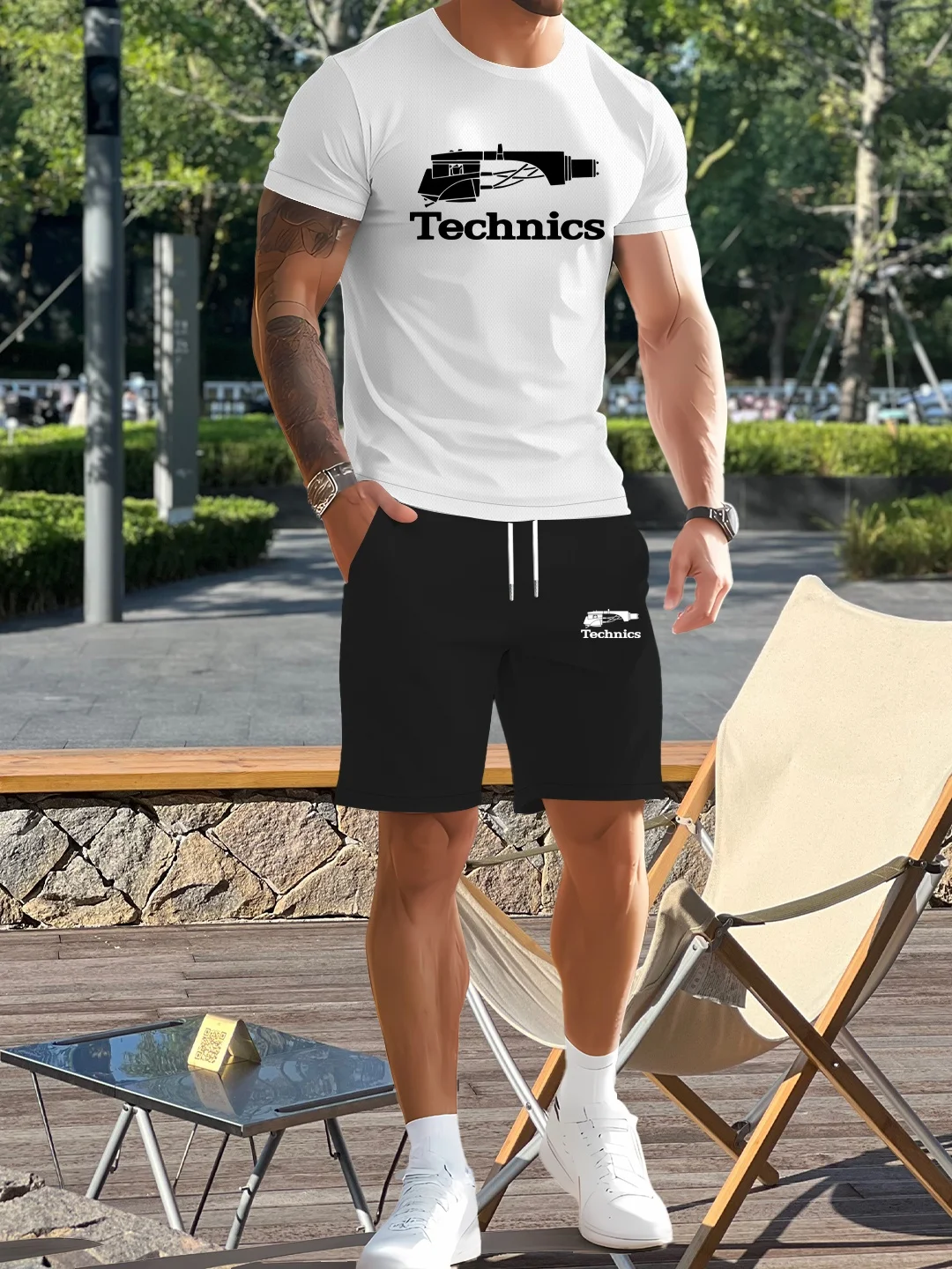 Man in casual outfit standing near chair.