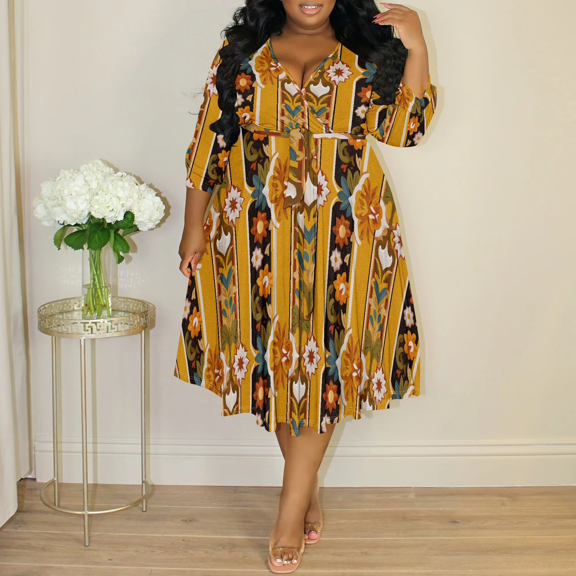 Woman wearing a stylish, patterned midi dress with long sleeves.