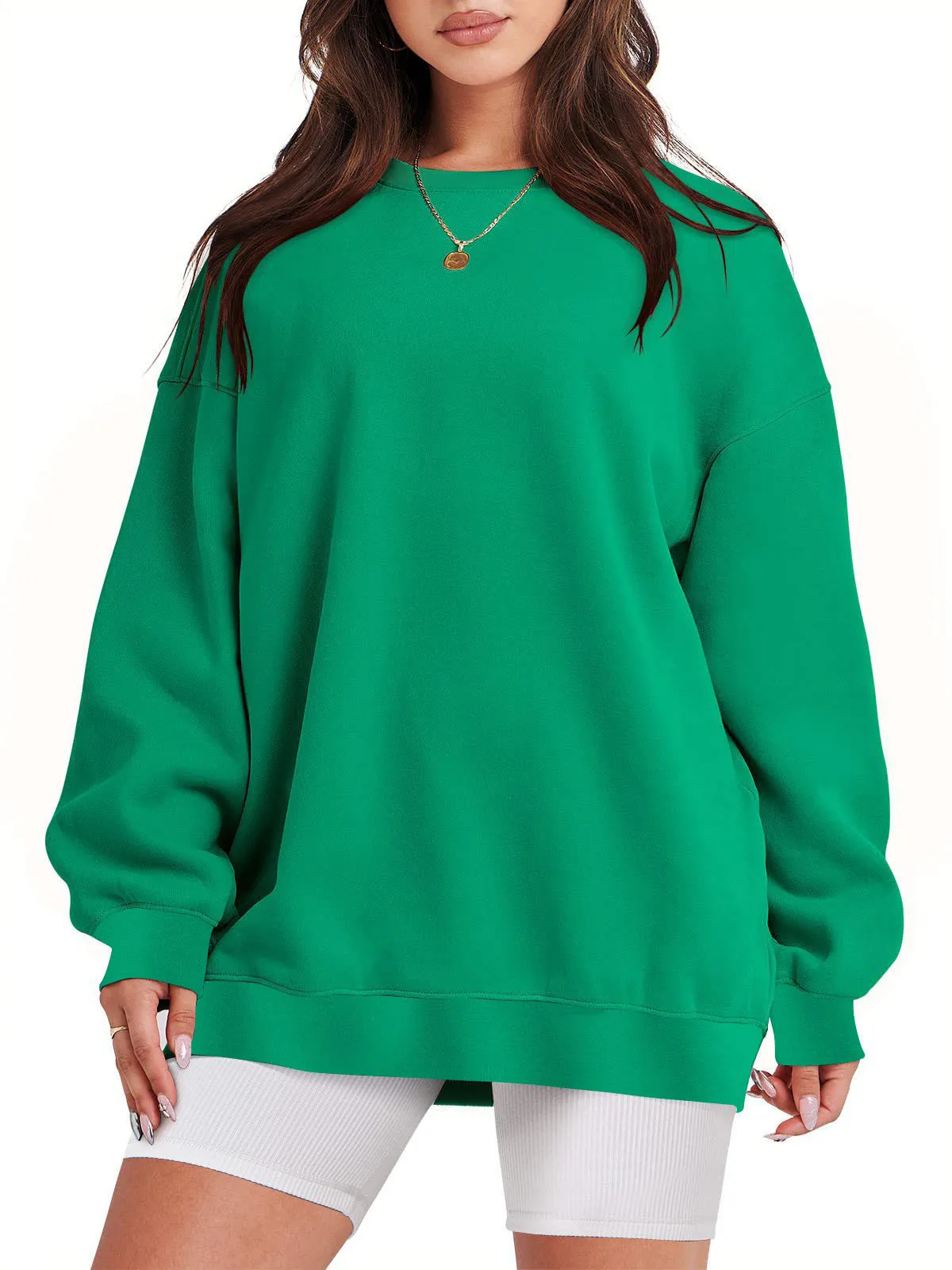 Woman wearing a loose green sweatshirt with long sleeves.