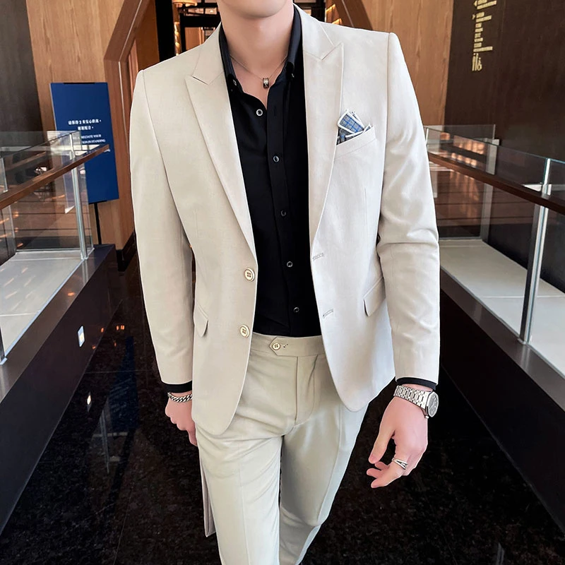 Man wearing beige suit and black shirt.