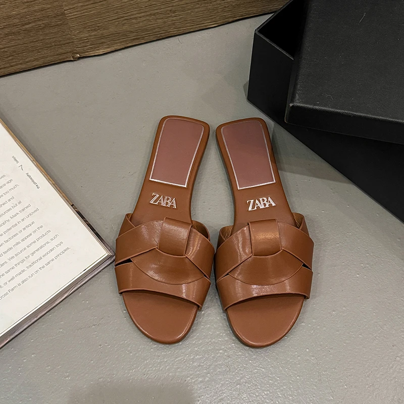 Pair of brown leather slip-on sandals with a cut-out design.