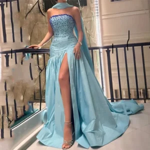 Elegant blue strapless gown with a thigh-high slit and matching gloves.
