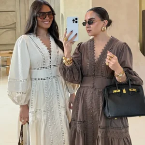 Two stylish women posing in elegant dresses and sunglasses.