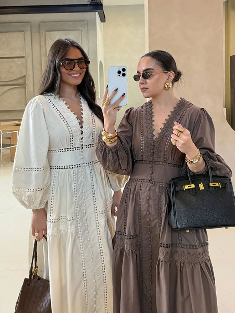 Two stylish women posing in elegant dresses and sunglasses.