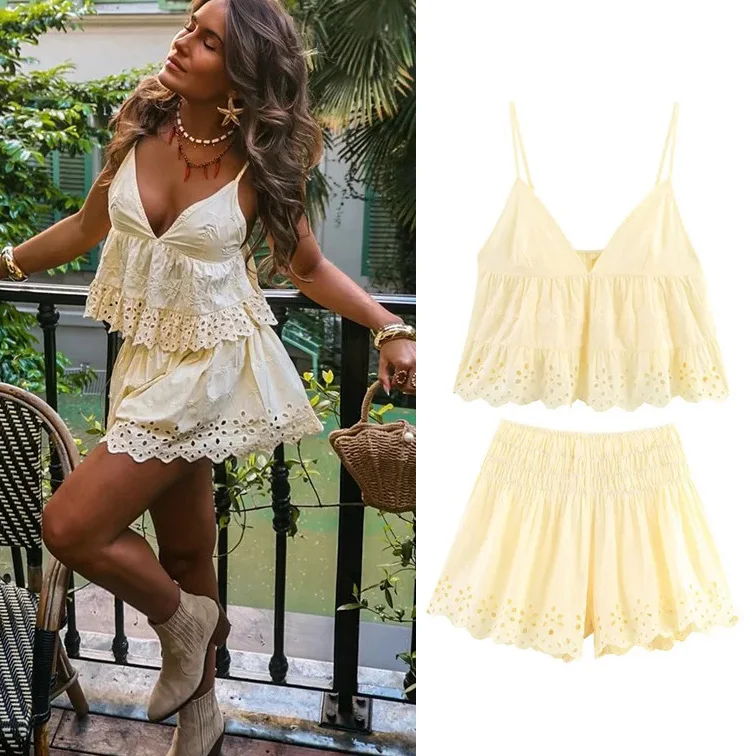 A woman wearing a cream-colored ruffled camisole and shorts set.