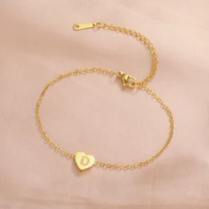 Delicate gold heart bracelet with a subtle engraved initial.