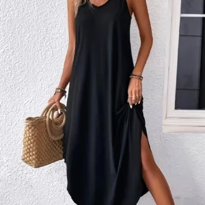 Elegant black sleeveless maxi dress with side slit and woven handbag.