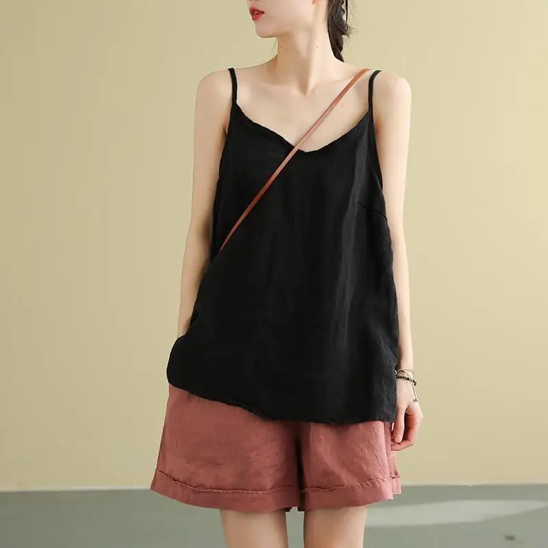Woman wearing a black camisole and brown shorts.